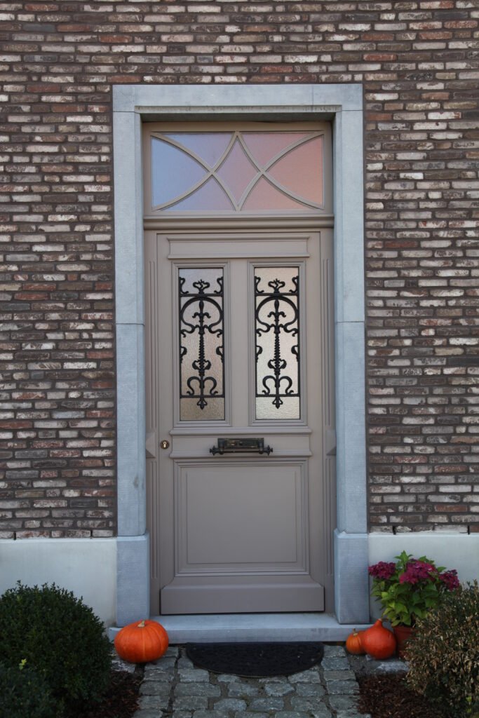 Detailafwerking van een massief houten voordeur, op maat gemaakt in eigen atelier.