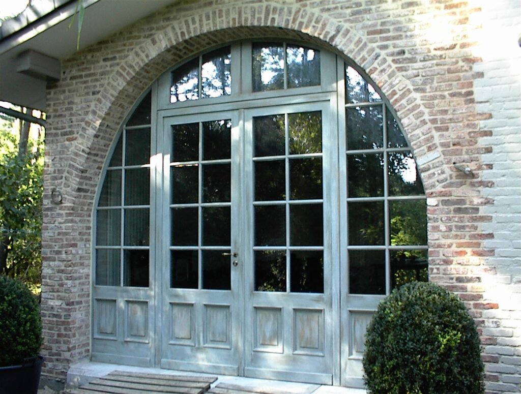 Klassieke houten toogpui bestaande uit openslaande deuren en zijlichten met authentieke kruishouten en onderpanelen.