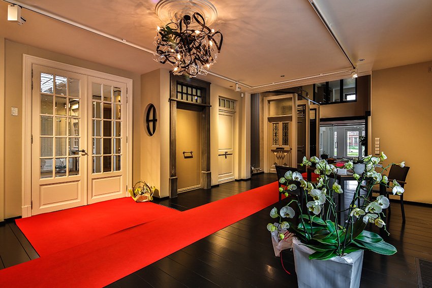 Sfeerbeeld van de toonzaal met witte dubbele houten deuren en exclusief beslag