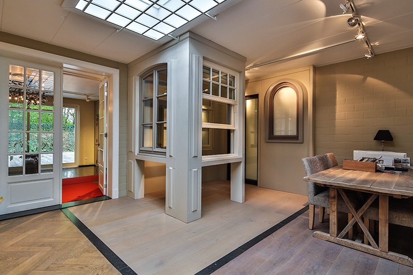 Detail van een houten raamprofiel en adviesruimte in onze toonzaal in Turnhout